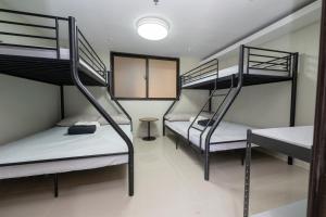 a room with three bunk beds and a light at The Warehouse Loft in Baguio