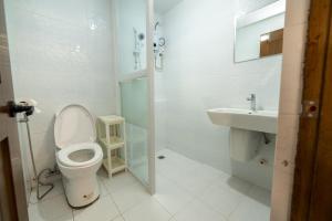a white bathroom with a toilet and a sink at The Warehouse Loft in Baguio +8 photos