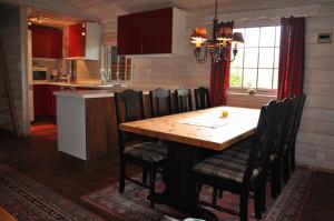 a kitchen and dining room with a wooden table and chairs at Liseth Pensjonat og Hyttetun in Garden