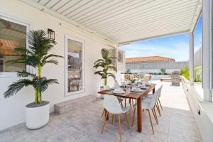a dining room with a table and chairs on a patio at 3BR Private Pool Retreat 4 Mins Drive by Bocobay in Palm-Eagle Beach
