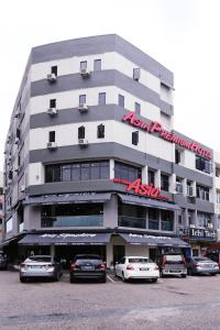 Asia Premium Hotel Kuala Terengganu في كوالا ترغكانو: مبنى كبير به سيارات تقف في موقف للسيارات