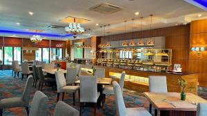 a restaurant with tables and chairs and a bar at Hotel Bumi Senyiur in Samarinda
