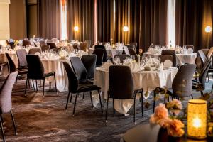 a room full of tables and chairs with white tablecloths at Scandic Frimurarehotellet in Linköping