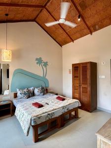 a bedroom with a large bed with a blue headboard at La GoYa at Anjuna Beachside in Goa +130 photos