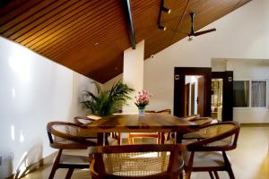 a dining room with a wooden table and chairs at Hunkal Stays in Chikmagalūr
