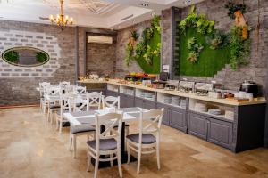 a dining room with white tables and chairs at Grand Hotel Baku Central Park in Baku