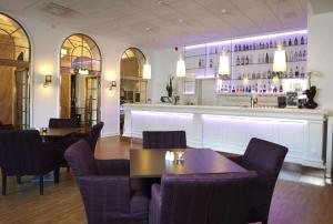 a restaurant with tables and chairs and a bar at Scandic Billingen in Skövde
