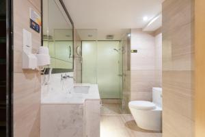 ein Badezimmer mit Waschbecken und Toilette in der Unterkunft QingMan Apartment Guangzhou Zhujiang New Town East Railway Station Branch in Guangzhou + 16 Fotos