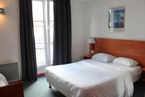 a bedroom with a bed and a large window at Hotel Le 21ème in Strasbourg