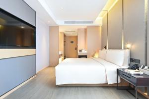 A bed or beds in a room at Atour Hotel Tianjin Wuqing Railway Station Florentia Village