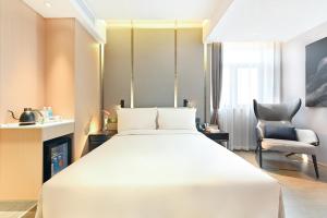 A bed or beds in a room at Atour Hotel Tianjin Wuqing Railway Station Florentia Village