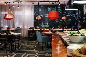 a restaurant with tables and chairs and red lamps at Scandic Östersund Syd in Östersund +35 photos