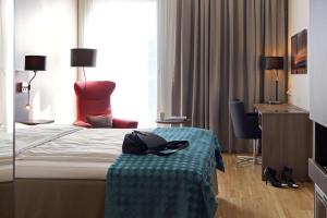 a hotel room with a bed with a hat on a table at Scandic Stavanger Airport in Sola