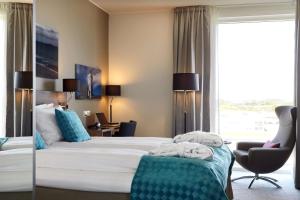 a hotel room with a bed and a chair and a window at Scandic Stavanger Airport in Sola
