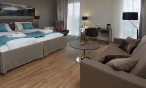 a bedroom with a bed and a living room at Scandic Stavanger Airport in Sola