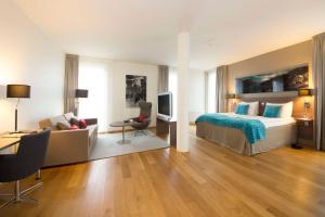 a hotel room with a bed and a couch and a television at Scandic Stavanger Airport in Sola