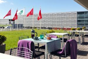 a group of tables with purple chairs and flags at Scandic Stavanger Airport in Sola