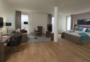 a bedroom with a bed and a desk and a couch at Scandic Stavanger Airport in Sola