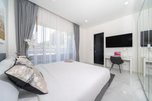 a white bedroom with a bed and a desk at Brand New 3 Bedroom Pool Villa 18 in Ban Saiyuan (1)