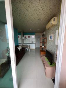 un salon avec un canapé et une télévision dans l'établissement Atlantis Condo Resort Pattaya, à Jomtien Beach 2 autres photos