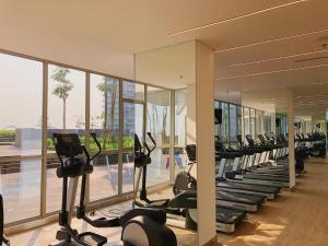 a gym with rows of treadmills and elliptical machines at Japandi Style One-Bedroom Apartment Gold Coast PIK in Jakarta