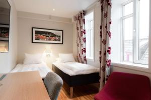 a room with two beds and a table and two windows at Scandic Byparken in Bergen +39 photos