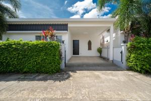 a white house with a gate and a driveway at The Greens Phuket Villa with swimming pool 18 in Ban Saiyuan (1)