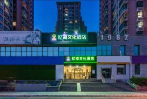 un edificio con un cartello sulla facciata di Yihai Cultural Hotel Coffee, fruits, snacks, a gym and a laundry room are provided for free in the lobby a Pechino