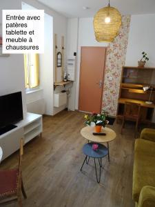 an apartment with a living room with a table and a tv at Chaleureux Henri IV in Pau +3 photos
