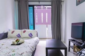 a living room with a couch and a television at Chic Suasana JB Suite Cozy Stay with Balcony in Johor Bahru