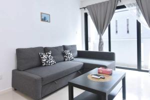 a living room with a gray couch and a table at Chic Suasana JB Suite Cozy Stay with Balcony in Johor Bahru