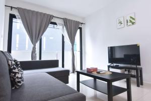 a living room with a couch and a tv at Chic Suasana JB Suite Cozy Stay with Balcony in Johor Bahru
