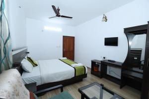 a hotel room with a bed and a tv at Lazo Golden Valley Resort , Munnar in Munnar