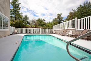 una piscina con sillas y una valla en Country Inn & Suites by Radisson, Asheville at Asheville Outlet Mall, NC en Asheville