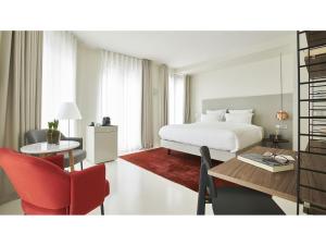 ブリュッセルにある9ホテル サブロンのベッド、テーブル、椅子が備わるホテルルームです。