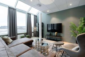 a living room with a couch and a tv at Scandic Hell in Hell