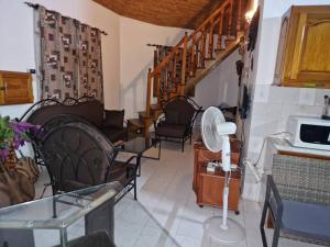 a living room with chairs and a spiral staircase at Maison 2 chambres dans résidence in Saly Portudal