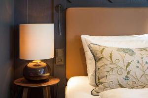 a lamp sitting on a table next to a bed at Scandic Holmenkollen Park in Oslo