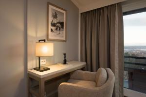 a room with a chair and a desk and a window at Scandic Holmenkollen Park in Oslo +37 photos
