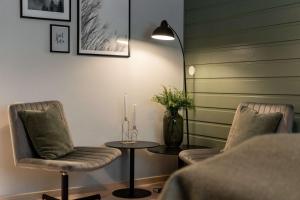 a room with two chairs and a table with candles at Olympiatoppen Sportshotel - Scandic Partner in Oslo
