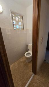 a bathroom with a toilet and a window at Maison 2 chambres dans résidence in Saly Portudal