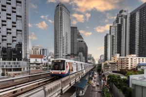 a train on a track in a city with buildings at Bangkok Marriott Hotel Sukhumvit in Bangkok