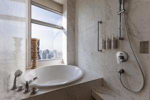 a white bathroom with a sink and a window at Bangkok Marriott Hotel Sukhumvit in Bangkok