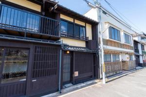 a building with doors and windows on a street at Kyoto Machiya inn offering scenic Kamo River views in Kyōto