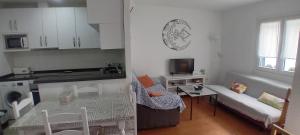 una cucina e un soggiorno con un divano e un tavolo di Eki a Conil de la Frontera