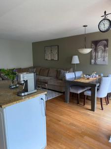 オタワにあるCute 3 Bedrooms Townhouse in Kanataのソファとテーブルのあるリビングルーム