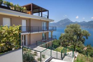 a house with a view of the water at Terrace of Wally - Apartment With Pool in Torri del Benaco