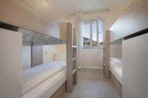 a bedroom with two bunk beds and a window at Terrace of Wally - Apartment With Pool in Torri del Benaco
