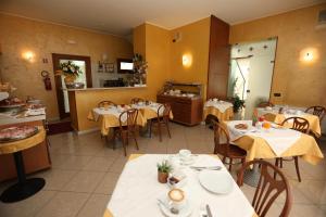 ein Restaurant mit Tischen und Stühlen und einer Küche in der Unterkunft Hotel Cris in Mestre