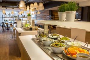 a buffet line with bowls of food in a restaurant at Scandic Meilahti in Helsinki